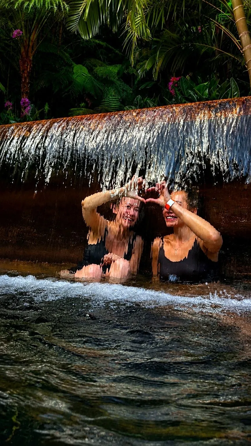 Two women in thermal baths under waterfall at Furnas, São Miguel Island Azores